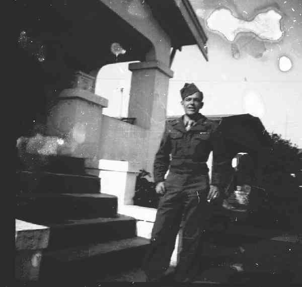 Frank in uniform in front of the steps of a house