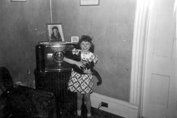 Janice holding a cat in front of a radio set