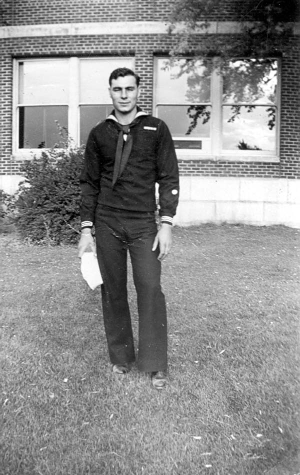 John in uniform standing in front of a brick building