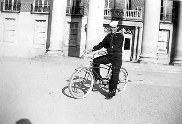 John in uniform on a bicycle