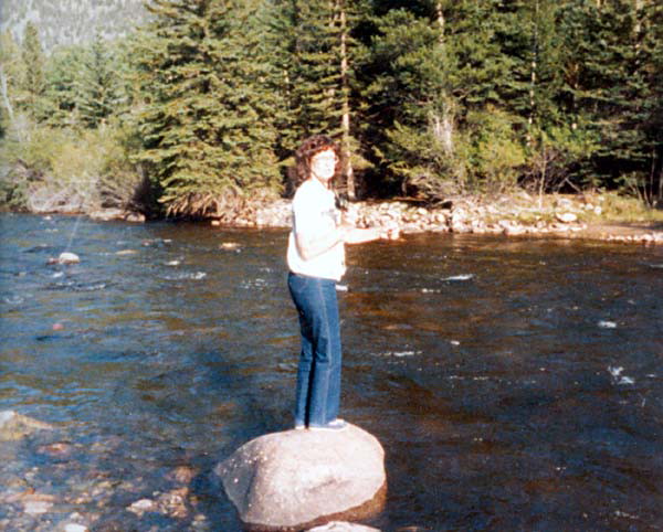 Naomi standing on a rock in a river