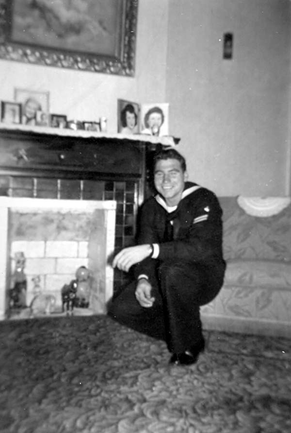 Pete in uniform, kneeling by a fireplace