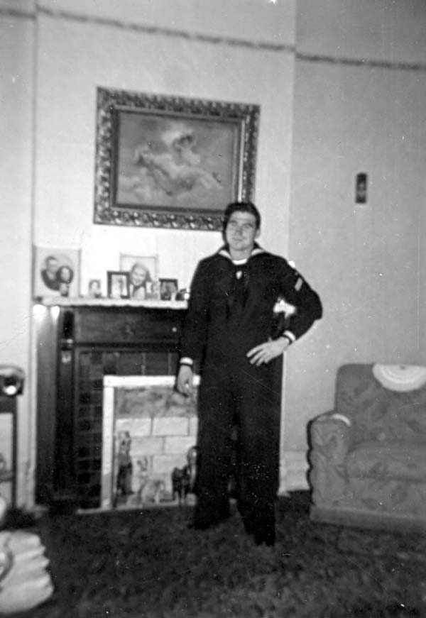 Pete in uniform, standing by a fireplace